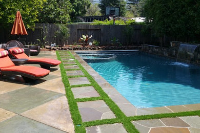 Foto de piscina con fuente alargada tradicional renovada de tamaño medio rectangular en patio trasero con adoquines de piedra natural