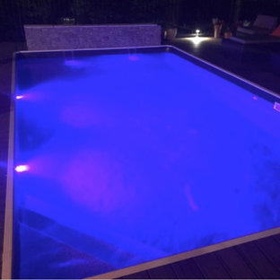 Idee per una grande piscina fuori terra moderna rettangolare dietro casa con pedane e fontane