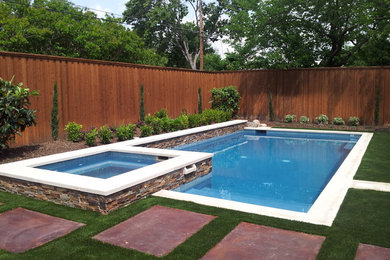 Immagine di una piscina design rettangolare dietro casa e di medie dimensioni con una vasca idromassaggio e lastre di cemento