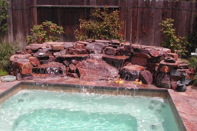 Ejemplo de piscinas y jacuzzis naturales clásicos de tamaño medio rectangulares en patio trasero con adoquines de piedra natural