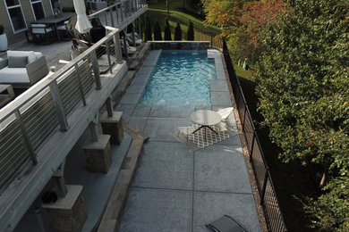 Large minimalist backyard stamped concrete and rectangular natural pool landscaping photo in St Louis