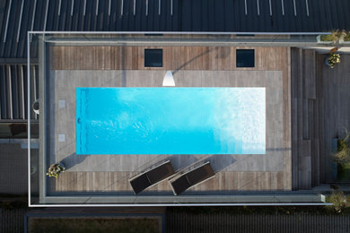 Ejemplo de piscina moderna de tamaño medio rectangular en azotea con adoquines de piedra natural