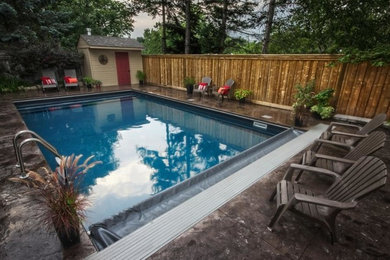 Imagen de piscina clásica renovada de tamaño medio rectangular en patio trasero con losas de hormigón