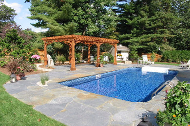 Großer Klassischer Schwimmteich hinter dem Haus in rechteckiger Form mit Natursteinplatten in Boston
