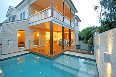 Cette image montre une petite piscine arrière design en L avec une terrasse en bois.