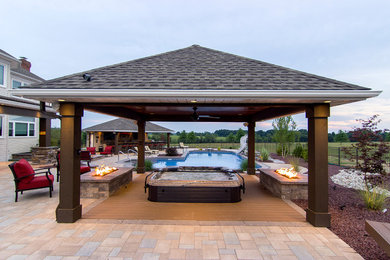 Ejemplo de piscinas y jacuzzis alargados contemporáneos grandes en forma de L en patio trasero con adoquines de hormigón