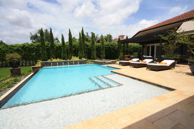 Diseño de piscina con fuente infinita clásica renovada grande a medida en patio trasero con adoquines de piedra natural