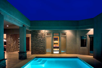 Imagen de piscina actual de tamaño medio rectangular en patio con losas de hormigón