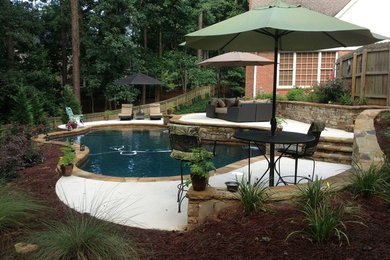 Mid-sized elegant backyard concrete and custom-shaped lap pool photo in Atlanta