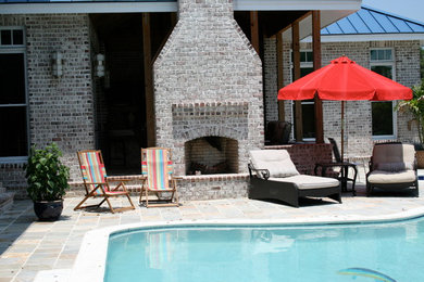 Foto de casa de la piscina y piscina tradicional grande a medida en patio trasero con adoquines de piedra natural