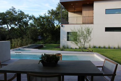 Diseño de piscinas y jacuzzis infinitos minimalistas de tamaño medio rectangulares en patio trasero con adoquines de hormigón
