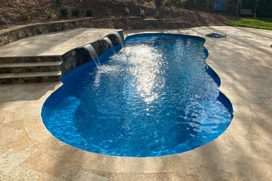 Large elegant backyard stone and custom-shaped natural pool fountain photo in Raleigh