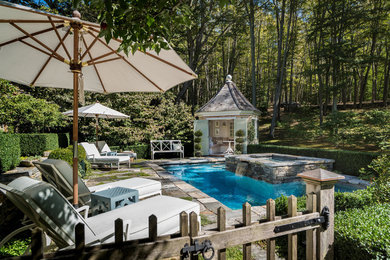 Elegant backyard stone and rectangular lap hot tub photo in New York