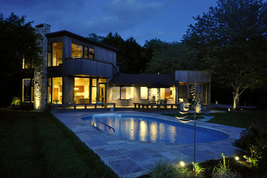 Foto di una grande piscina monocorsia minimal personalizzata dietro casa con pavimentazioni in pietra naturale