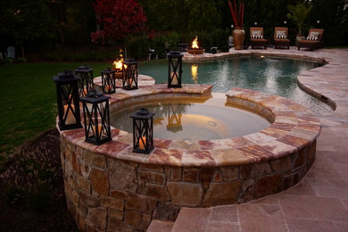 Modelo de piscinas y jacuzzis naturales contemporáneos grandes a medida en patio trasero con adoquines de piedra natural