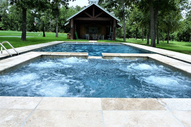 Diseño de piscinas y jacuzzis naturales actuales grandes rectangulares en patio trasero con adoquines de piedra natural