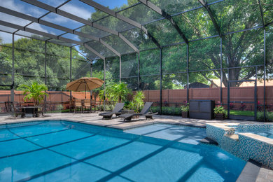 Imagen de piscinas y jacuzzis alargados clásicos renovados grandes a medida en patio trasero con adoquines de piedra natural