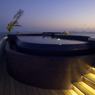 Foto di una piscina a sfioro infinito design personalizzata sul tetto con una vasca idromassaggio e pedane