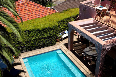 Imagen de piscina alargada moderna grande a medida en patio trasero con losas de hormigón