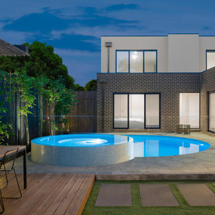 Contemporary backyard round pool in Melbourne with a hot tub and stamped concrete.