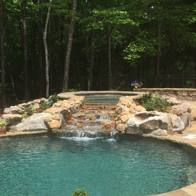 Example of a mid-sized mountain style backyard stone and custom-shaped natural hot tub design in Atlanta