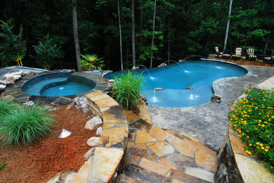 Inspiration for a large rustic backyard stone and kidney-shaped infinity water slide remodel in Atlanta