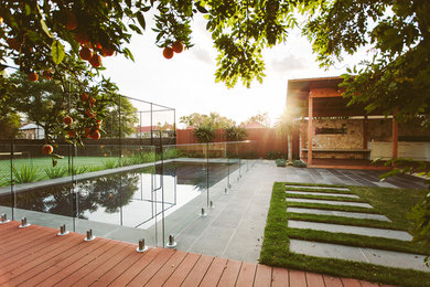 Bild på en stor funkis rektangulär träningspool på baksidan av huset, med poolhus och naturstensplattor