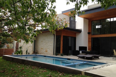 На фото: большой естественный, прямоугольный бассейн на заднем дворе в стиле модернизм с покрытием из каменной брусчатки