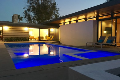 Inspiration for a mid-sized contemporary backyard concrete and rectangular pool remodel in Los Angeles