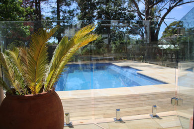 Large nautical back rectangular above ground swimming pool in Sydney with with pool landscaping and decking.