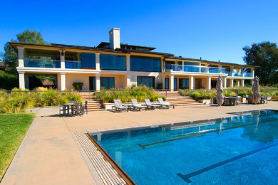 Foto de piscina infinita actual de tamaño medio rectangular en patio trasero con losas de hormigón