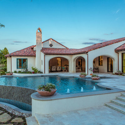 Pool - huge southwestern backyard stone and custom-shaped infinity pool idea in Dallas