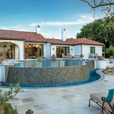 Pool - huge southwestern backyard stone and custom-shaped infinity pool idea in Dallas