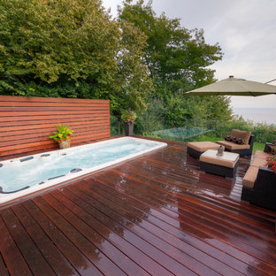 Ispirazione per una piscina monocorsia design rettangolare di medie dimensioni e dietro casa con una vasca idromassaggio e pedane