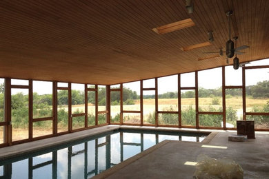 Imagen de piscina tradicional grande interior con losas de hormigón