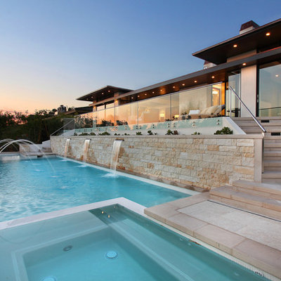 Inspiration for a mid-sized contemporary backyard stone and rectangular infinity hot tub remodel in Los Angeles