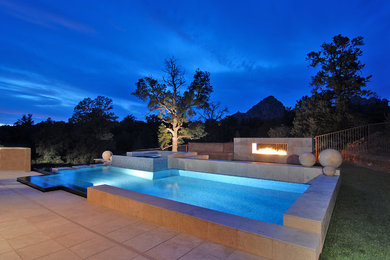 Pool fountain - mid-sized modern backyard custom-shaped infinity pool fountain idea in Phoenix with decking