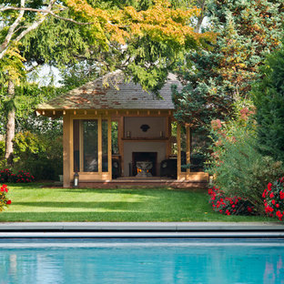 Large asian backyard rectangular pool in New York with a pool house and concrete pavers.