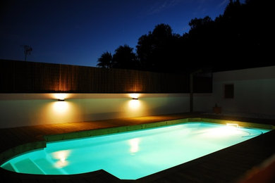 Mid-sized beach style rooftop rectangular pool fountain photo in Other with decking