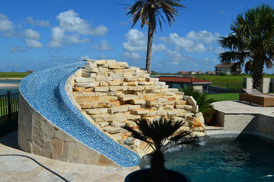 Diseño de piscina con tobogán natural marinera a medida en patio trasero