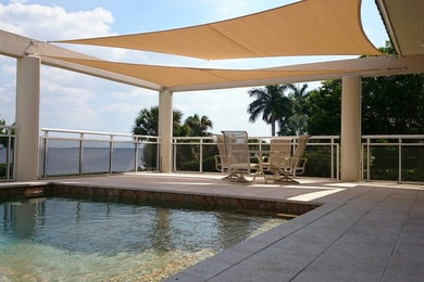 Example of a mid-sized minimalist backyard pool design in Miami