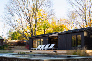 Diseño de casa de la piscina y piscina alargada contemporánea grande rectangular en patio trasero con adoquines de hormigón