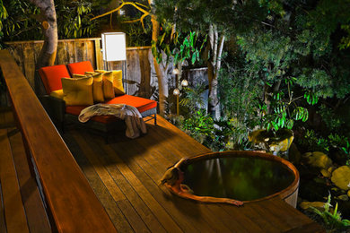Hot tub - small tropical backyard round hot tub idea in Santa Barbara with decking