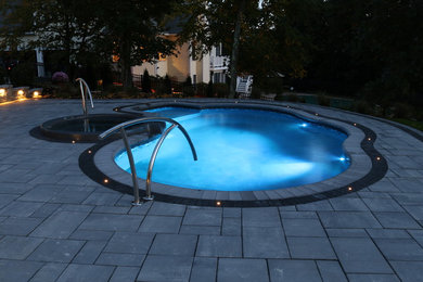 Источник вдохновения для домашнего уюта: бассейн среднего размера, в форме фасоли на заднем дворе в современном стиле с джакузи и мощением тротуарной плиткой