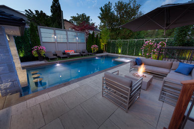 Großer Moderner Pool hinter dem Haus in rechteckiger Form mit Wasserspiel und Natursteinplatten in Sonstige