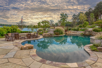 Inspiration for a large coastal backyard stone and custom-shaped natural hot tub remodel in Detroit