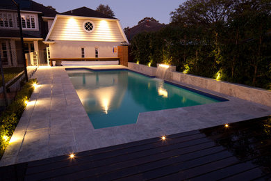 Diseño de piscina con fuente minimalista de tamaño medio rectangular en patio trasero con adoquines de piedra natural