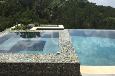Diseño de piscinas y jacuzzis infinitos contemporáneos de tamaño medio rectangulares en patio trasero con suelo de baldosas