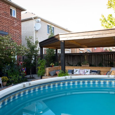 Example of a mid-sized arts and crafts backyard round and concrete paver aboveground pool fountain design in Toronto