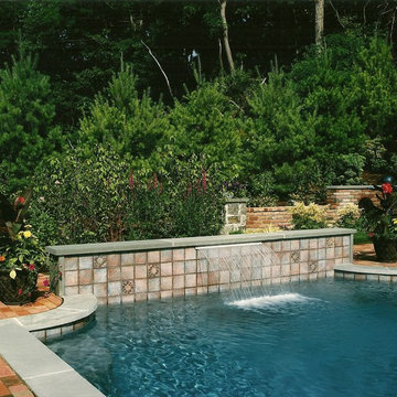 Small Pool with Raised Tile Water Feature and Brick Retaining Wall with Stone Pi